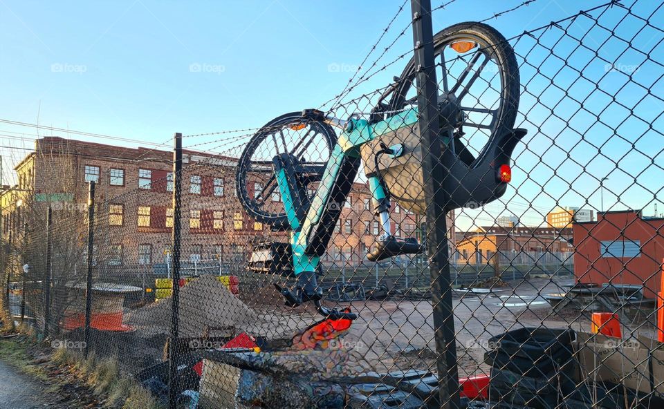 Bicycle hanging on a fence