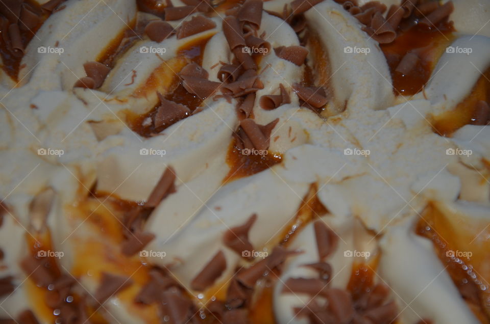 this photo makes you hungry because it represents a good caramel ice cream with its caramel shavings and caramel sauce
