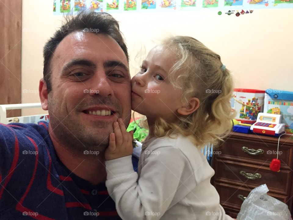 Little girl kissing father's cheek