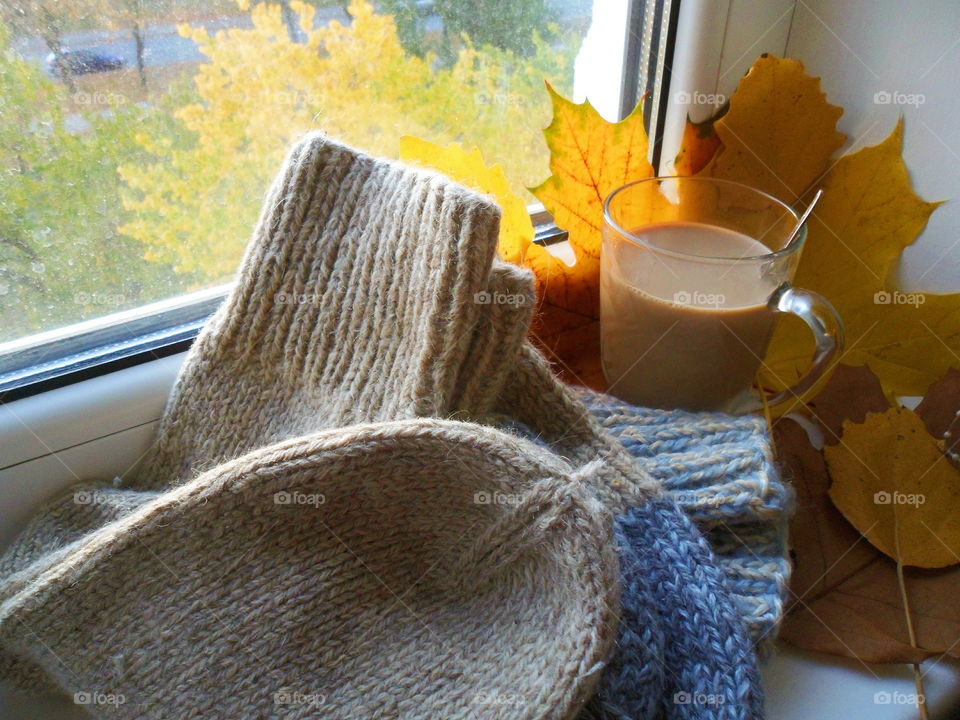 a cup of hot chocolate and warm socks on the windowsill