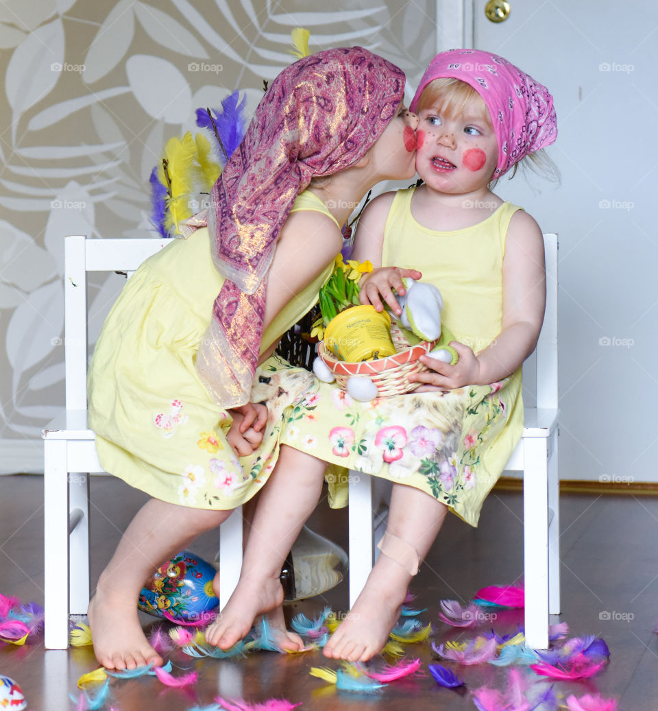 Two young sisters having fun infront of the camera with easter theme.