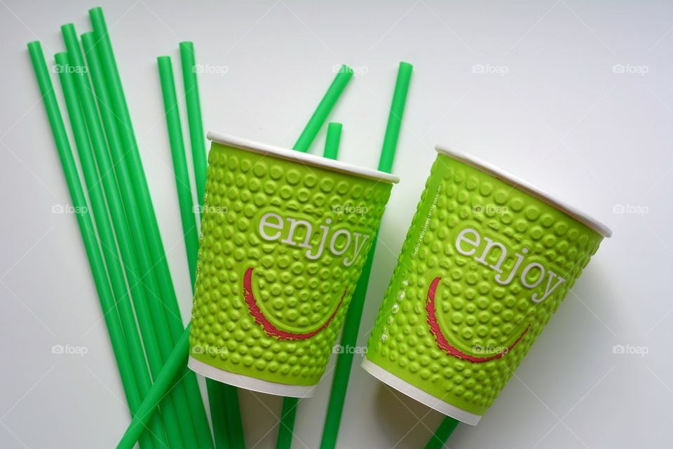 Green disposable cup and green drinking straws