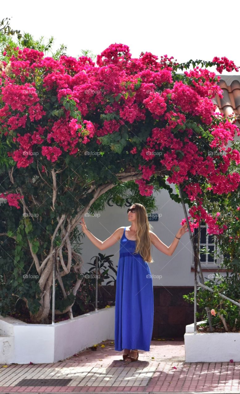 woman under the arch of tropical fliwers on la gomera canary island in Spain