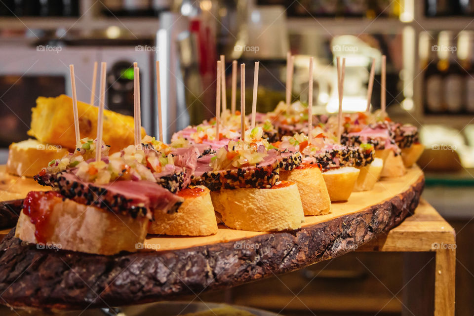 National famous food of Northern Spain pinchoses lie on a large wooden platter on a wooden showcase