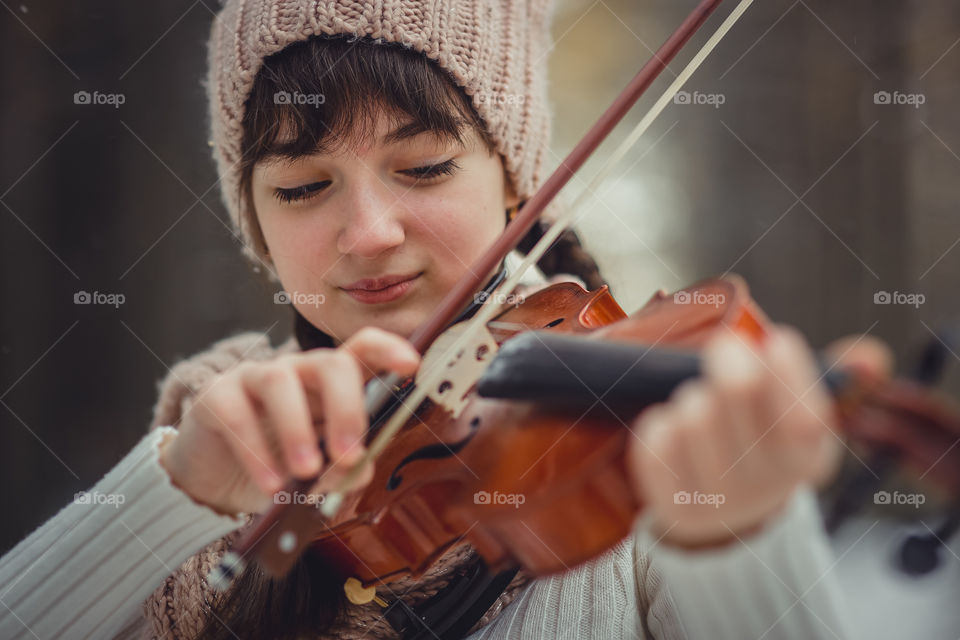 Teenage girl portrait with violin in winter park