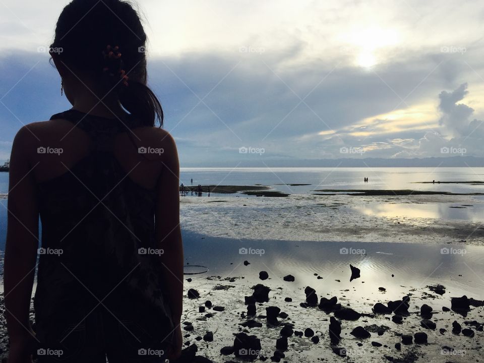 Sunset at the beach. A little girl viewing the sunset at the beach