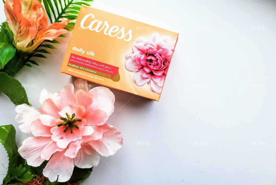 Left side oriented: The new look Caress bar single pack of daily silk on a white background next to two matching florals.