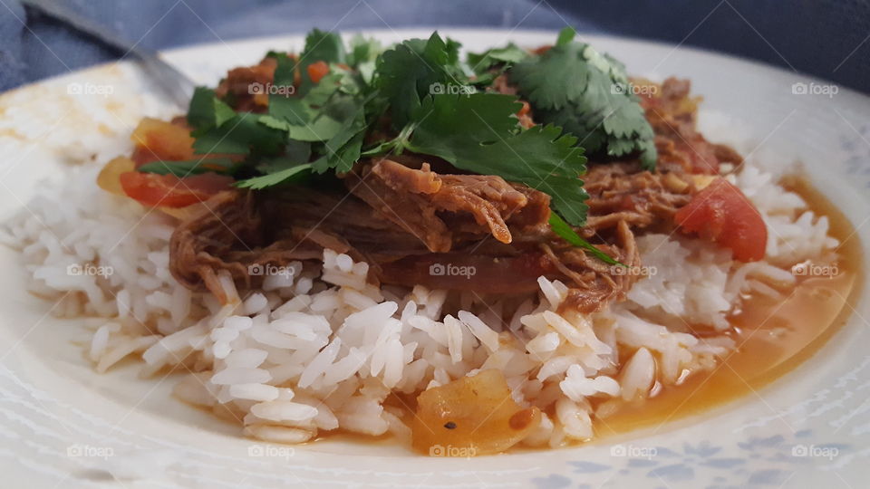 Ropa vieja over rice topped with cilantro