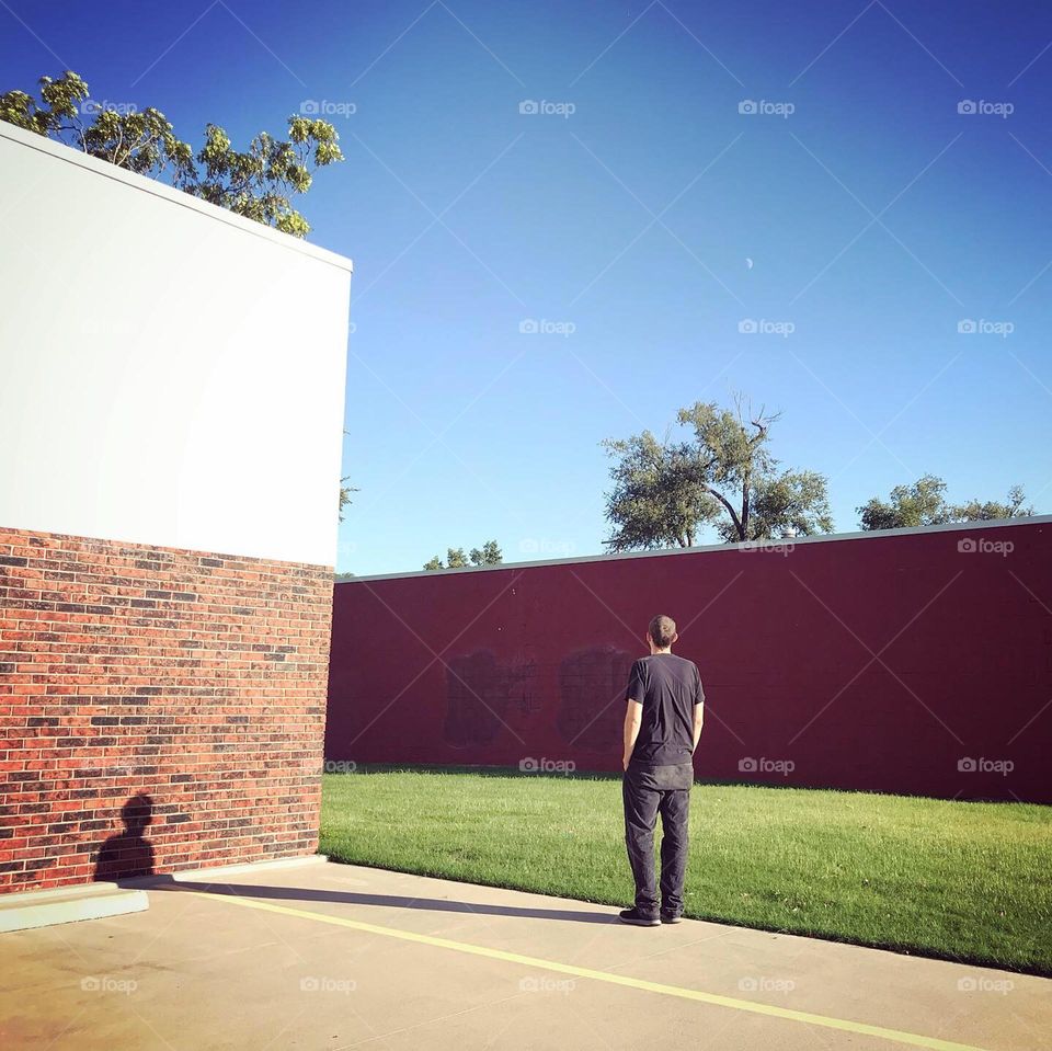Man with Shadow on Brick Building 