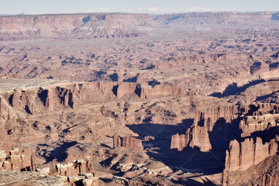 Canyonlands National Park on a sunny spring evening. This is a long landscape shot demonstrating the drama and size of this natural feature.