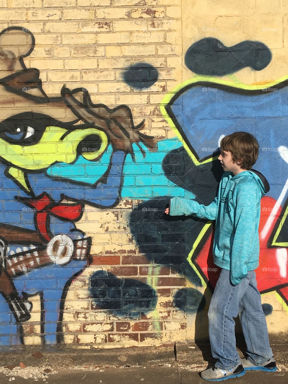 Boy standing near the graffiti wall