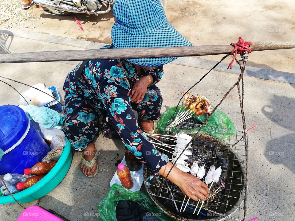 Cambodian woman cooks street food