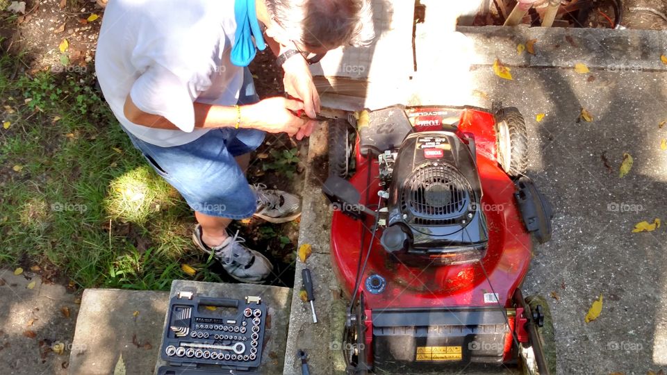 From where I stand I see a hard-working individual trying to figure out what is wrong with the lawn mower