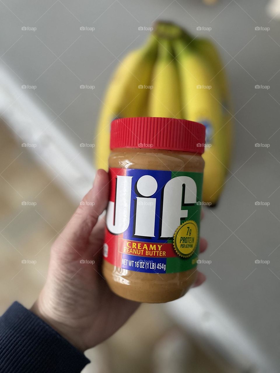 Big Jif peanut butter, making a snack, peanut butter and bananas, eating healthy after a workout, making healthy snacks, woman’s hand holding peanut butter 