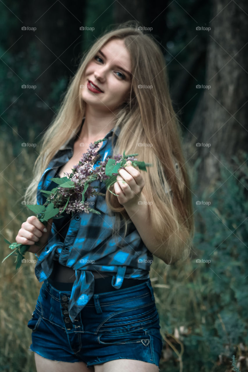 A girl with blond hair in a plaid shirt and short denim shorts on a background of trees and nature,
Girl, woman, man, people, blonde, blonde hair, checkered shirt, shorts shorts, denim shorts, forest, nature, trees, grass, feelings, emotions, tenderness, love, lifestyle, lifestyle, recreation