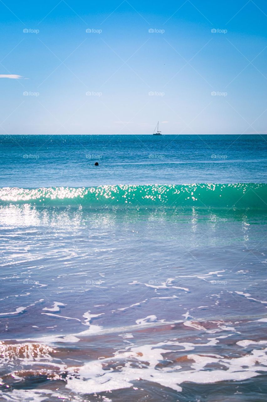 Green wave and a boat