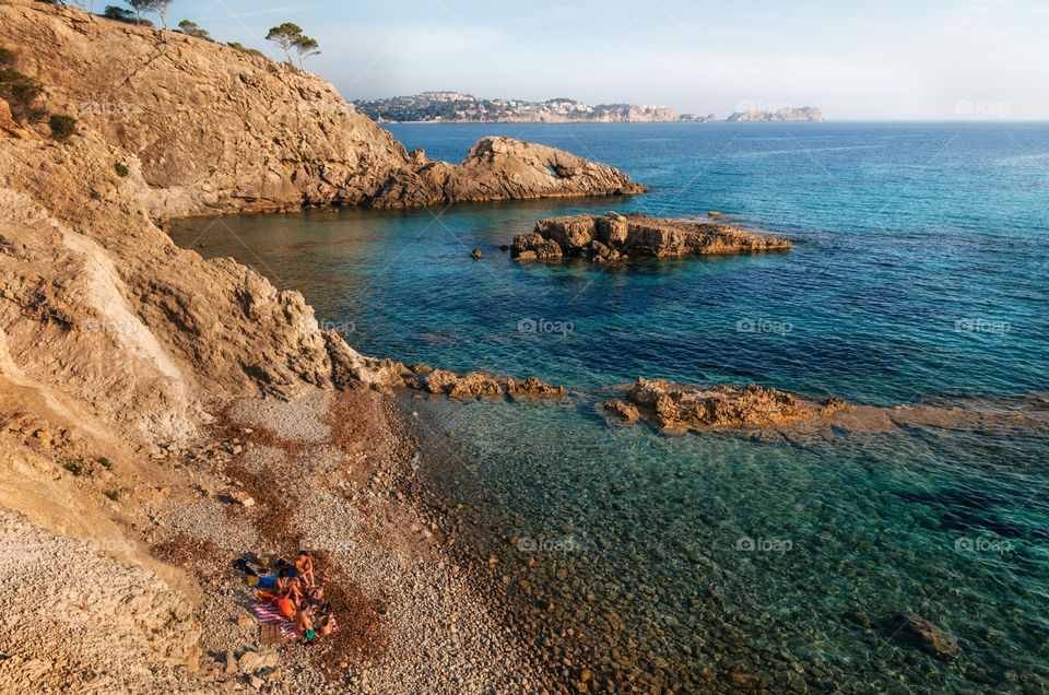 View of the cozy bay of Mallorca Island with azure water. Hidden rocky beach with stones and cliffs, Spain