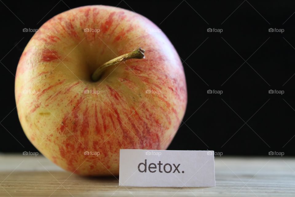 An apple with the word detox next to it