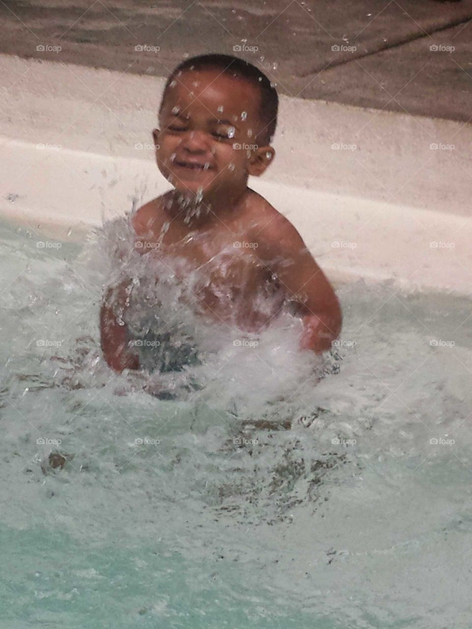 Smiling little boy enjoying in pool