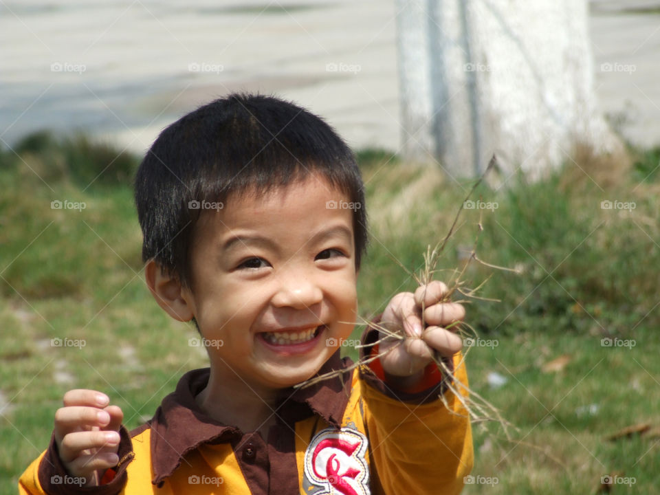 Happy asian boy holding dust