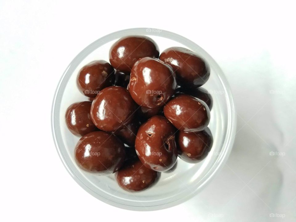 shot glass of chocolate covered candies, white backdrop
