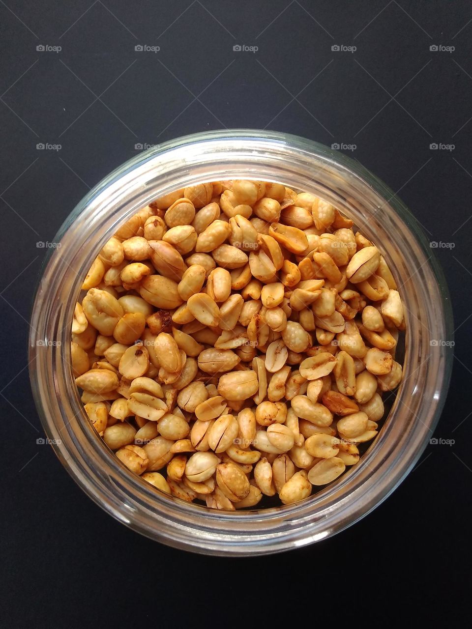 Fried peanuts in a glass container, serve as snacks during celebrations such as Ramadan and Eid.