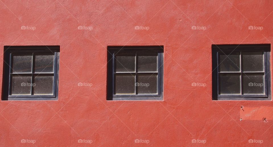 A red dwelling with three unwashed windows