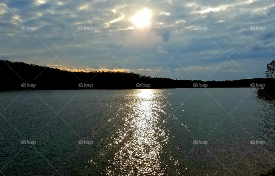 sun peeking through clouds as evening starts