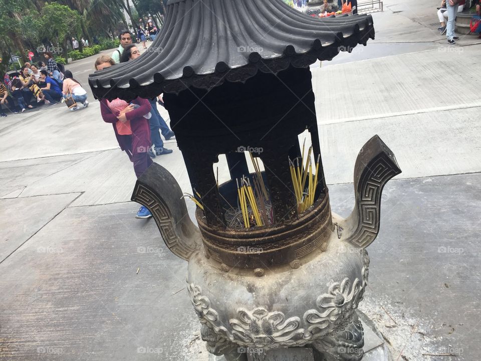 Buddhist Prayers to Buddha, by lighting incense, and letting their smokey prayers float to Buddha. Ancient Pottery-Ngong Ping Village, Po Lin Monastery, Lantau Island, Hong Kong. 