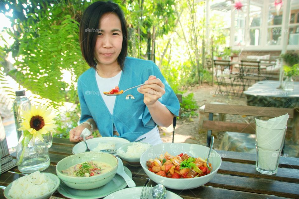 Woman eating Thai food  Which has a very delicious flavor  Is a unique style of Thai food that is famous throughout the world.  Very delicious food, Thai food.