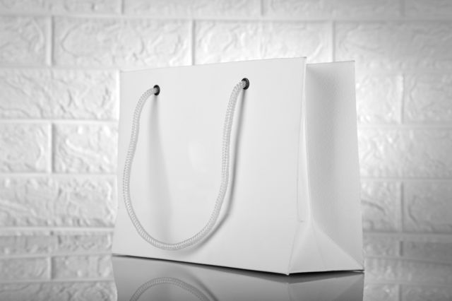 White shopping bag with brick wall in the background