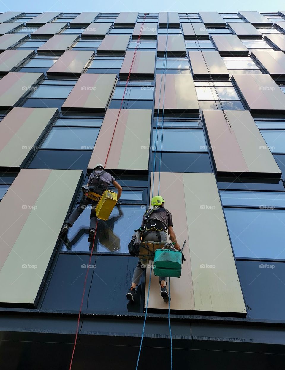 From the ground up. Windows cleaners clean windows in a multi-storey building.