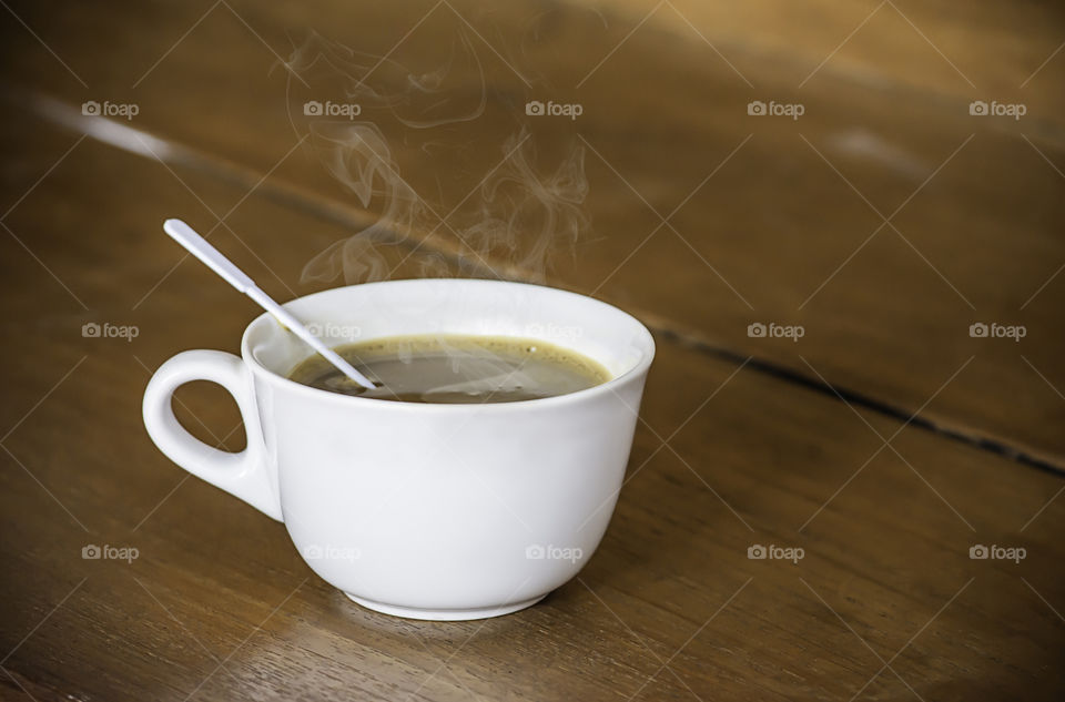 Hot coffee in white glass on wooden table