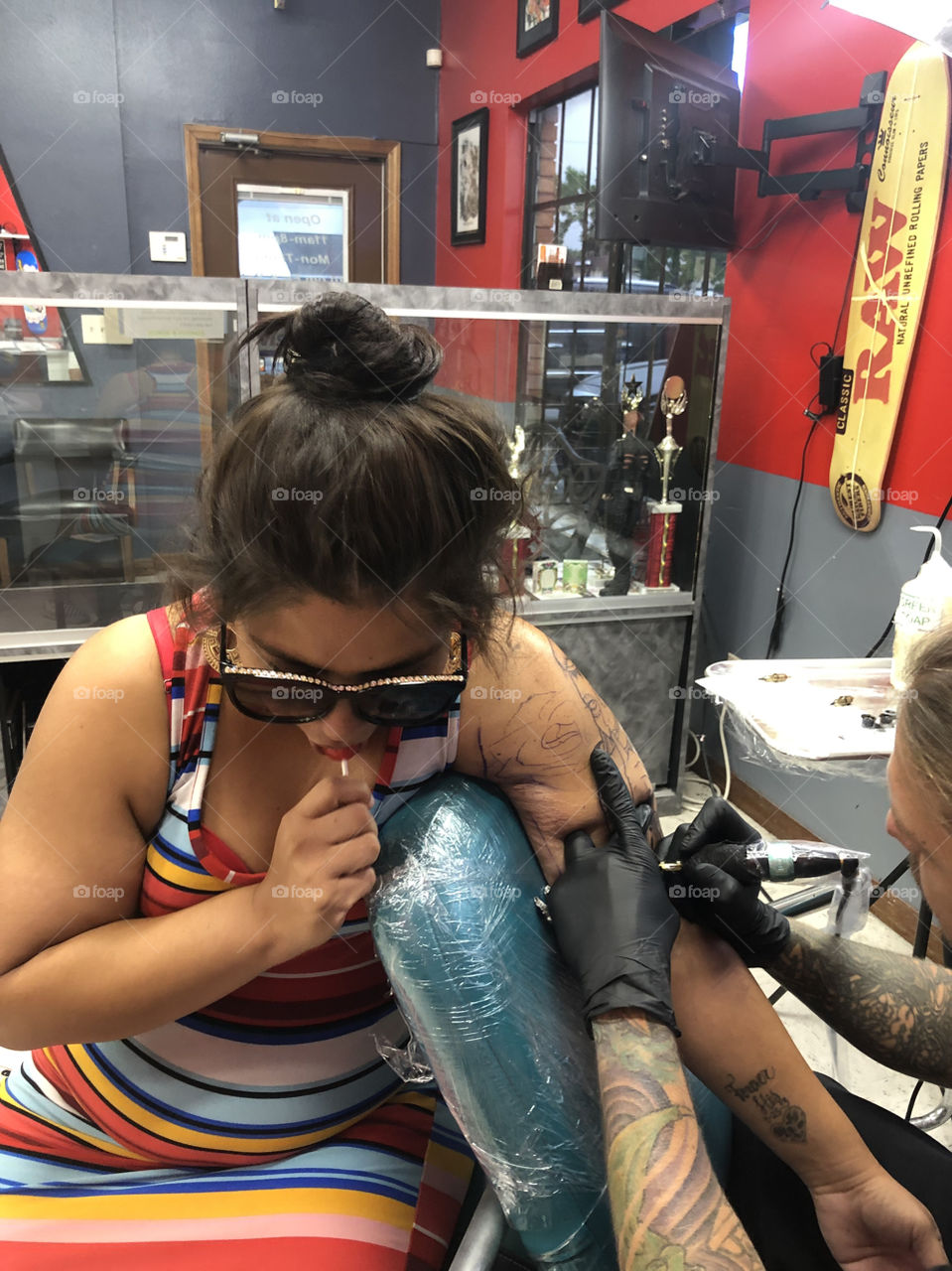 Spanish woman sucks on Lollipop to help take the pain as she sits for 8 hours of no stop pain for a life permanent art piece she will treasure forever
