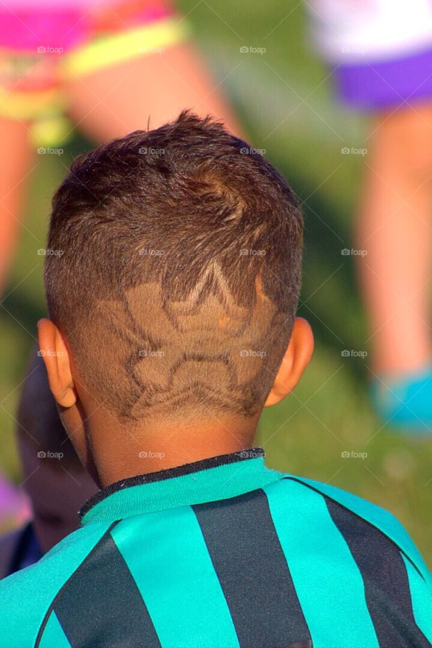 Under armor logo shaved into the back of a soccer players head. 