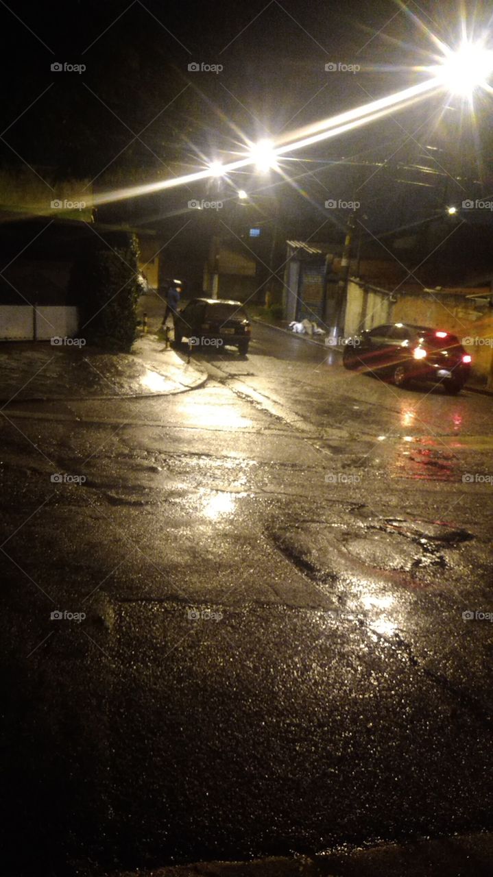na cobertura de um guarda chuva, à proteção e um conforto de um carro, onde as luzes e faróis iluminam nossa cidade