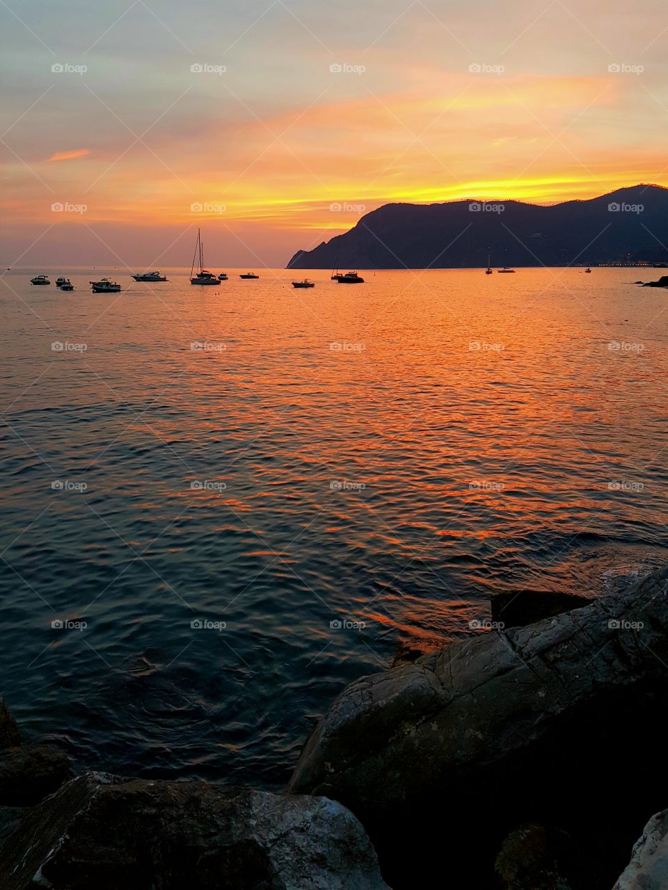 Silhouette of boats in sea at sunset, Manarola, Italy