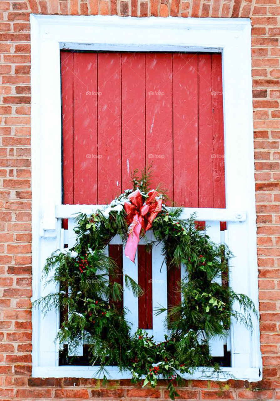 Holiday door decorations. Farm house door decorated for the holidays and covered in snow