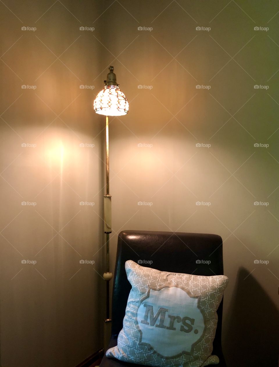 Cozy warm corner of domestic interior with chair pillow and floor lamp 