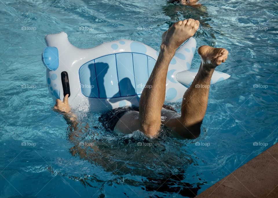 Feet in the air from falling off inflatables in the pool