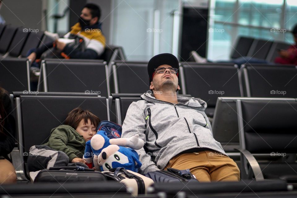 Man and a child are sleeping in the airport