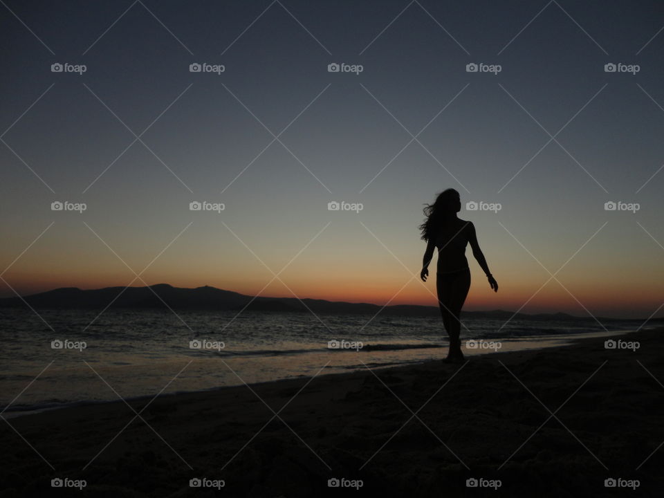 girl silhouette walking on beach