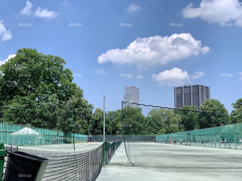 Tennis court at Central Park New York. Beautiful day during summer. Blue sky and clouds hanging.