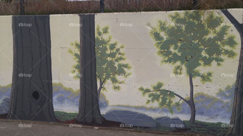 Forest scene painting on parking lot retaining wall.