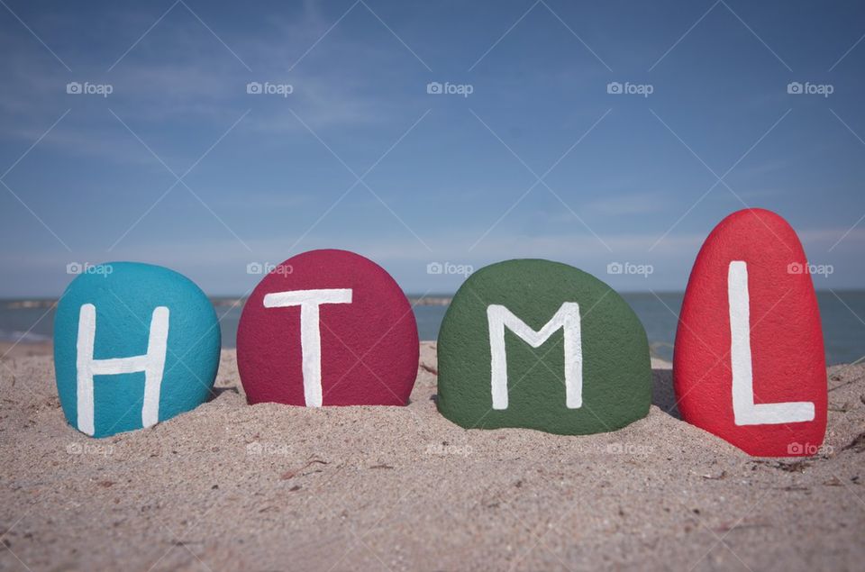 HTML concept on colourful stones with beach background