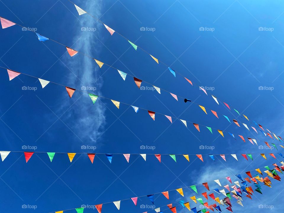 Low angel view of multicolored prayer flags against blue sky