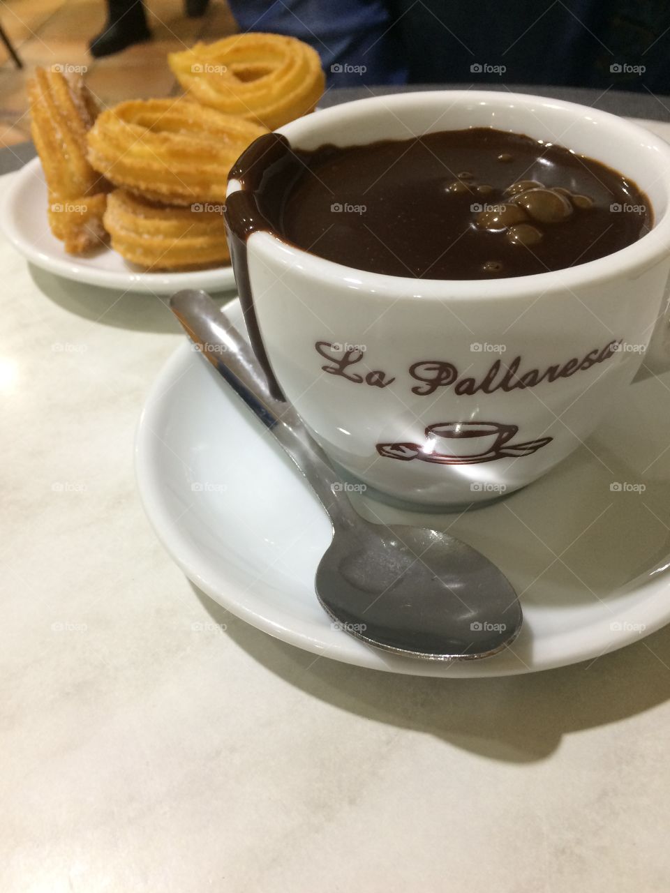 Closeup of delicious churros y chocolate at famous cafe, churros shop in Barcelona, Spain