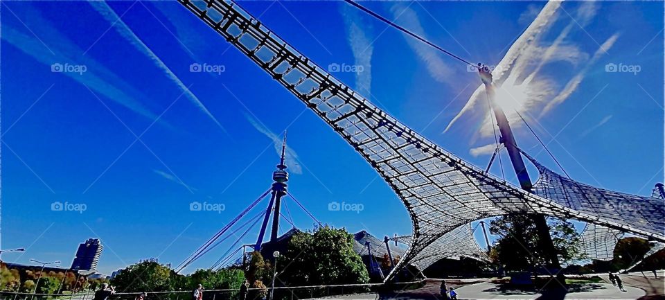 Seen from an especially streamlined warped angle in this exposure is once again the stadium especially constructed for the „Olympic Games“ of 1972 in „Munich“. Germany. 2022. Hypnotic Productions