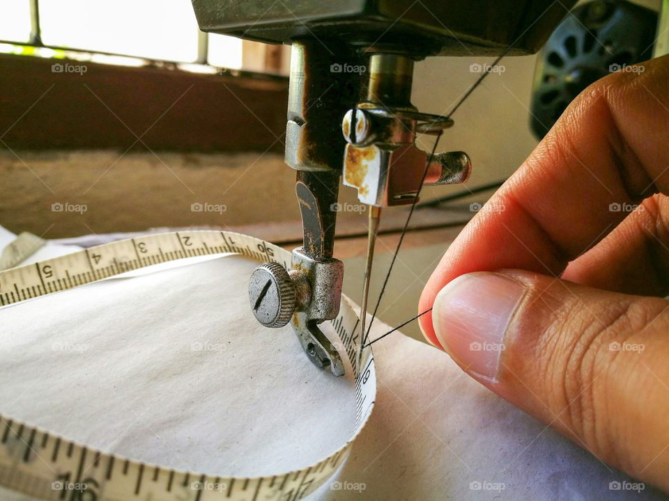 Close-up of hand holding thread