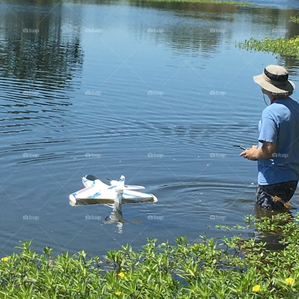 Man n water operating a remote control drone watercraft 